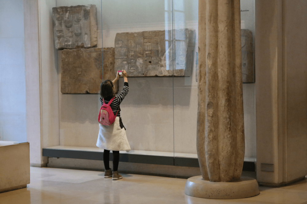 We all capture something? Little girl taking pictures in the Louvre.