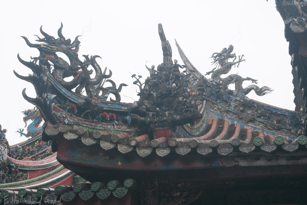 Carved figures anbd dragons on temple roof